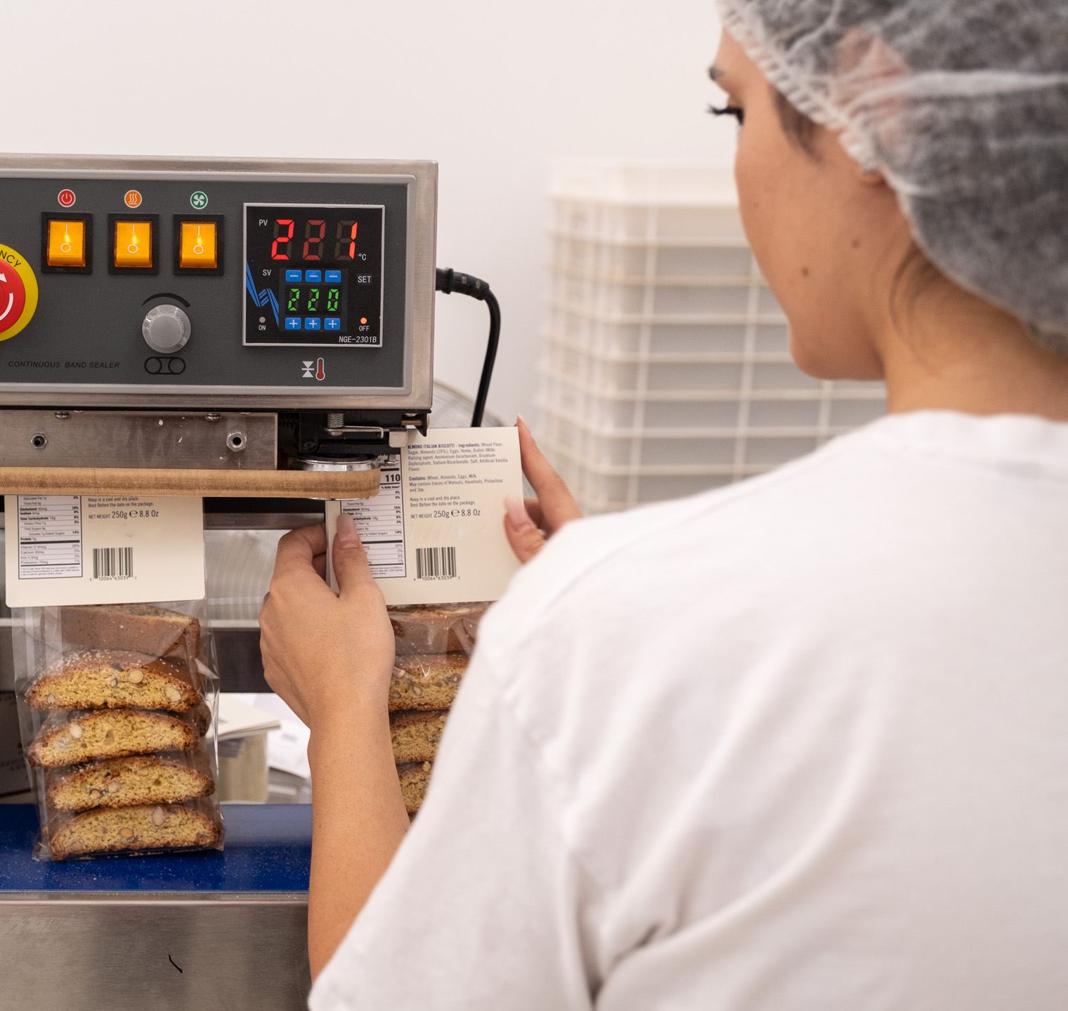 Un'operatrice controlla l'etichetta di un sacchetto di cantucci in reparto